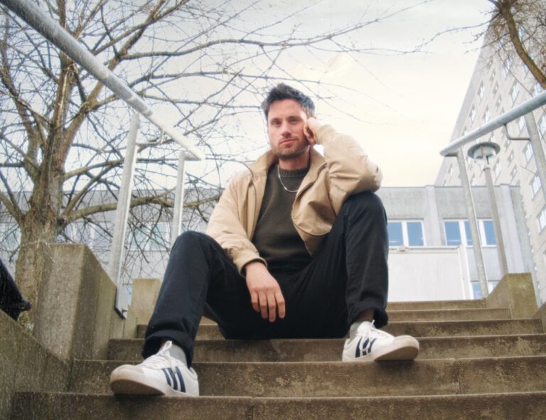 Videofreelancer Patrick Winzler sitzt auf einer Treppe in Berlin