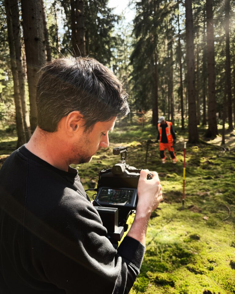 Videograph filmt Arbeiter im Wald