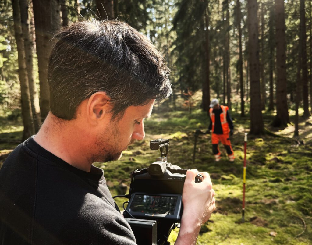 Videograf filmt Arbeiter im Wald für einen Industriefilm
